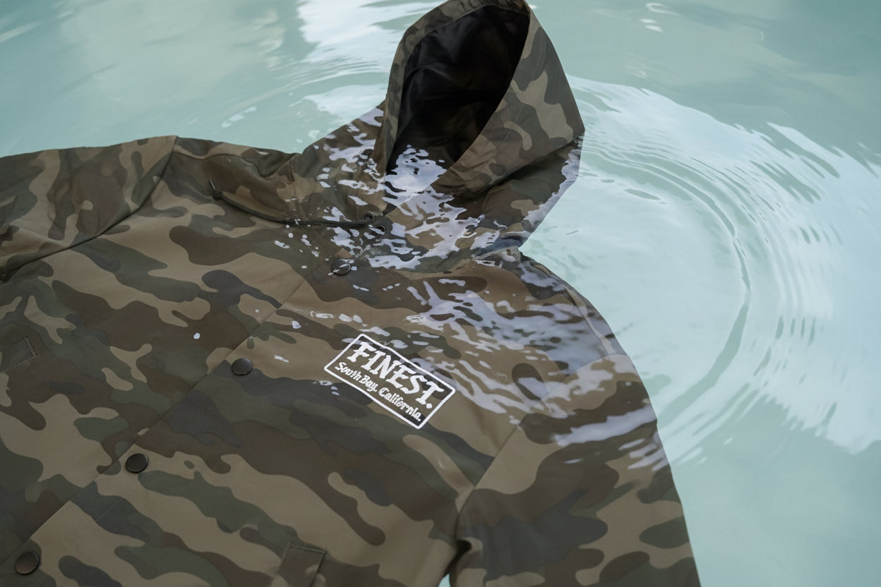 Camouflage jacket with 'Finest' logo on a textured surface
