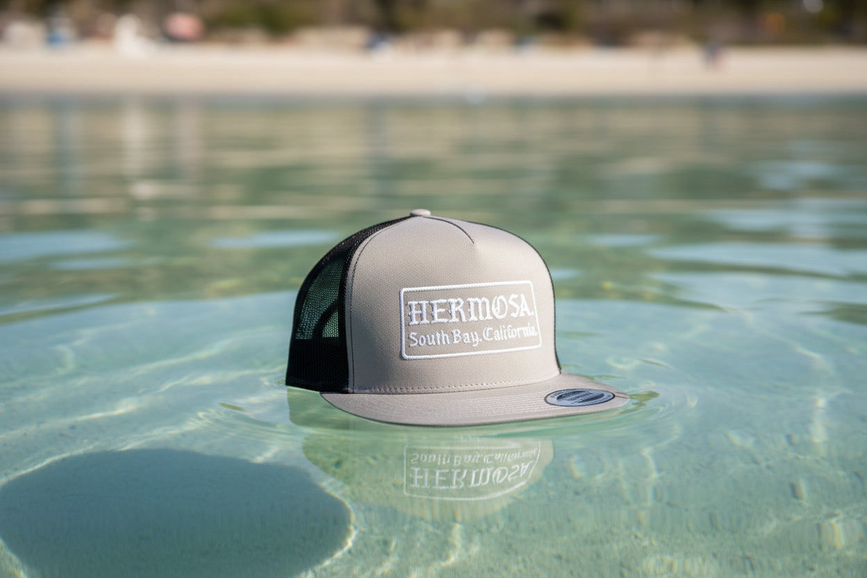 Gray cap with 'Hermosa South Bay, California' text on a textured surface