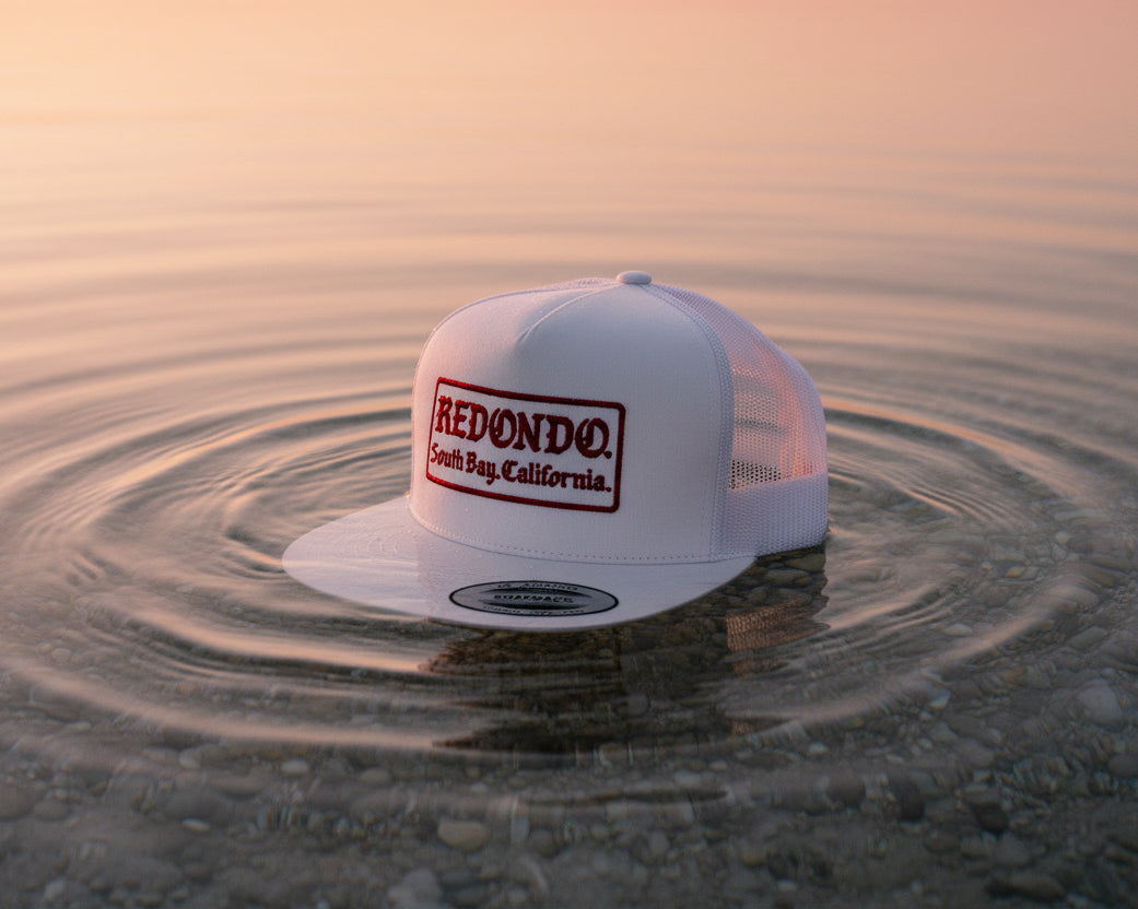 White cap with 'Redondo' logo on a textured surface